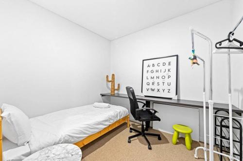 ein Schlafzimmer mit einem Bett und einem Schreibtisch mit Stuhl in der Unterkunft Four bedroom apartment with facilities in Olympic Park in Sydney