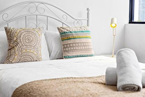 a bedroom with a white bed with pillows at Four bedroom apartment with facilities in Olympic Park in Sydney