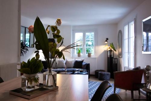 un salon avec une table avec un vase de fleurs dessus dans l'établissement Nessmann, à Sarlat-la-Canéda