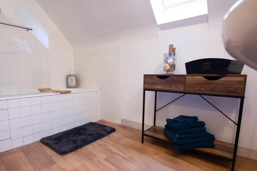 ein Bad mit einem Waschbecken und einem Tisch mit Handtüchern in der Unterkunft Nessmann in Sarlat-la-Canéda