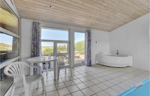 ヴィデ・サンデにあるAmazing Home In Hvide Sande With House Sea Viewのバスルーム(バスタブ、テーブル、椅子付)