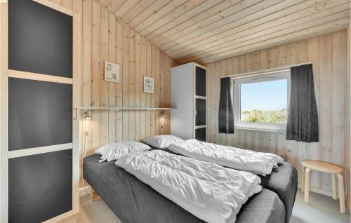 a bedroom with a bed and a window at Awesome Home In Hvide Sande With 4 Bedrooms, Sauna And Wifi in Hvide Sande