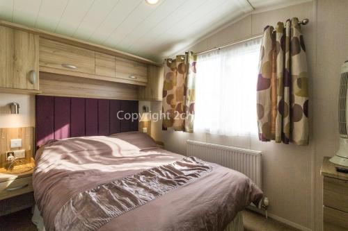 a bedroom with a bed and a window at Superb 8 Berth Dog Friendly Caravan At Haven Caister In Norfolk Ref 30009d in Great Yarmouth