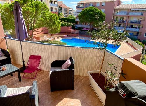 - un balcon avec une piscine dans un bâtiment dans l'établissement Coeur de Fréjus, L'AMPHITHÉÂTRE, appartement 3 pièces climatisé, terrasse, barbecue, piscine & parking, à Fréjus
