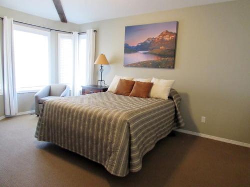 a bedroom with a bed and a painting on the wall at Paradise Canyon Golf Resort, Signature Luxury Villa 380 in Lethbridge