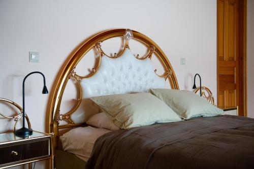 a bed with a wooden headboard and pillows on it at Villa Pasithea in Korfos