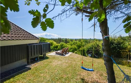 a yard with a swing and a tree at Stunning Home In Sjællands Odde in Yderby