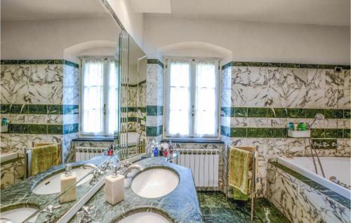 a bathroom with two sinks and a tub at Lovely Apartment In Cogorno With Wifi in Cogorno
