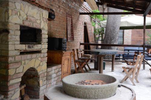 an outdoor patio with a stone fireplace and a table and chairs at Tiflis Hotel in Tbilisi City
