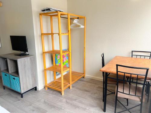 a room with a table and a wooden book shelf at Hawaiian Monarch 1105 condo in Honolulu