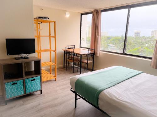 1 dormitorio con 1 cama, TV y mesa en Hawaiian Monarch 1105 condo, en Honolulu