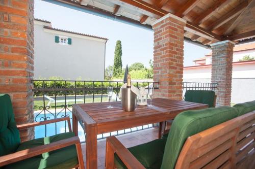 a patio with a wooden table and chairs at Villa Petra in Poreč