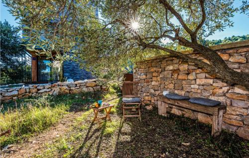 a stone wall with a bench and a tree at Amazing Home In Dragove in Dragove