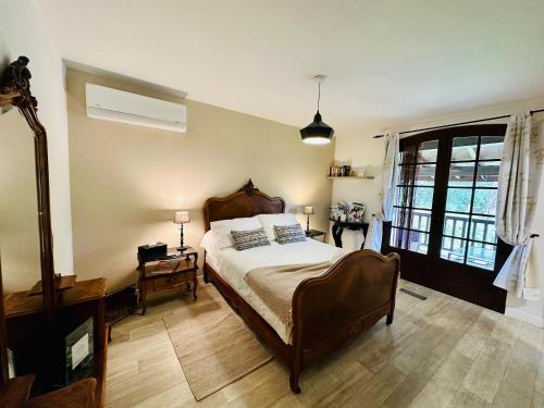Suite Armagnac, relaxing gite near Nogaro في نوغارو: غرفة نوم بسرير كبير ونافذة