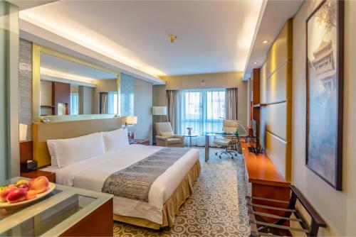 a hotel room with a bed and a table with a bowl of fruit at Guo Ji Yi Yuan Hotel in Beijing