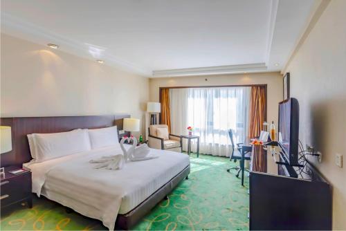 a hotel room with a large bed and a desk at Guo Ji Yi Yuan Hotel in Beijing
