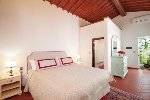 モンテスペルトリにあるVilla I Leoniのベッドルーム(大型ベッド1台付)、バスルームが備わります。