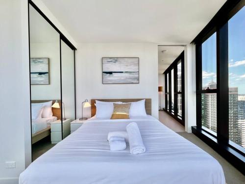- une chambre avec un grand lit blanc et de grandes fenêtres dans l'établissement Highrise best location 2baths, à Melbourne