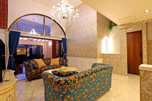 a living room with two couches and a chandelier at The Ocean Hills 大東温泉 LIBERTY RESORT in Kakegawa