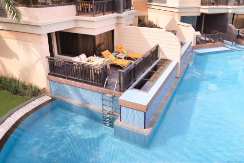 a house with a swimming pool next to a building at Anantara The Palm Dubai Resort in Dubai