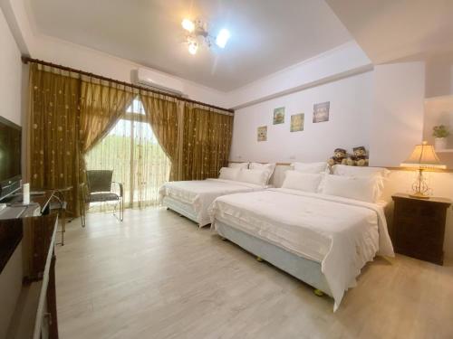 Habitación grande con 2 camas y TV. en Hualien Lidu House, en Hualien City