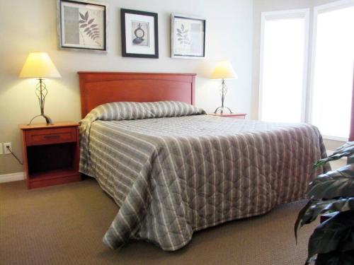 - une chambre avec un lit et deux lampes sur les tables dans l'établissement Paradise Canyon Golf Resort, Signature Luxury Villa 382, à Lethbridge