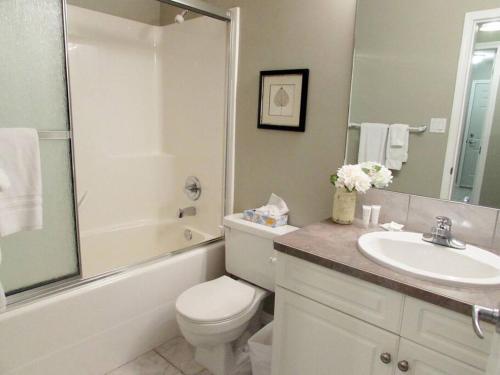 ein Bad mit einem WC, einem Waschbecken und einer Dusche in der Unterkunft Paradise Canyon Golf Resort, Signature Luxury Villa 382 in Lethbridge