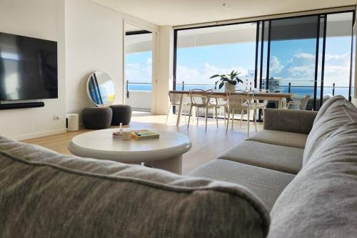 a living room with a couch and a table at Modern luxury with breathtaking ocean views in Gold Coast