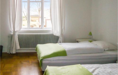 two beds in a room with a window at Lovely Home In Trelleborg With Sauna in Trelleborg