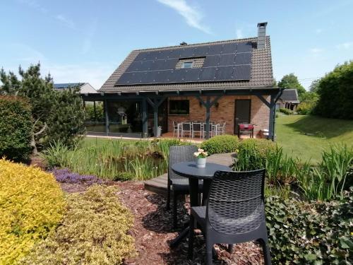 uma casa com painéis solares no telhado em LE CLOS DU MONTYS em Louveigné