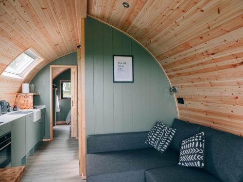 a living room with a couch and a wooden ceiling at Eastfield Glamping Farm in Spennithorne