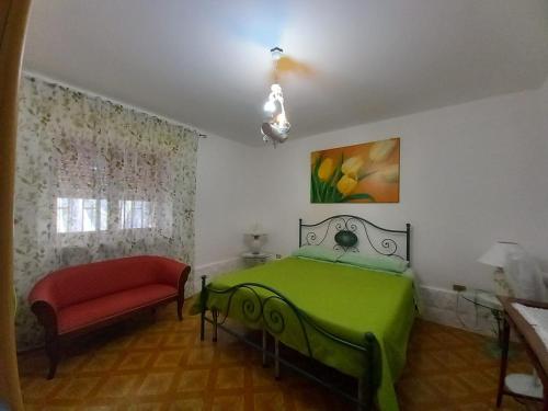 - une chambre avec un lit vert et une chaise rouge dans l'établissement Casa Trullo Sole, à Cisternino