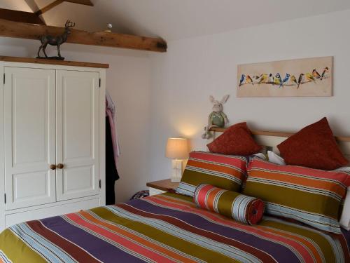a bedroom with a bed and a white cabinet at The Olde Barn in Dunholme