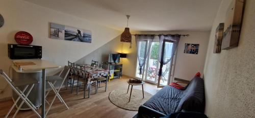 un salon avec un canapé et une table dans l'établissement Charmant appart 40 m2 proche plage et marché Arago 141 rue de la printanière Le Musée, à Les Sables-dʼOlonne