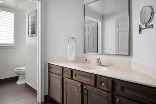 a bathroom with a sink and a mirror and a toilet at Marriott's Ocean Pointe in Palm Beach Shores
