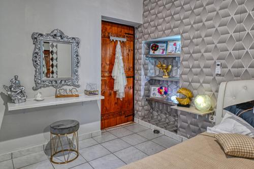 um quarto com uma cama, um espelho e um banco em Sargos Rooms Nopigeia em Nopíyia