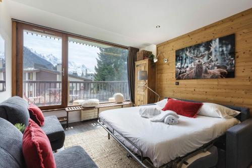 ein Schlafzimmer mit einem Bett und einem großen Fenster in der Unterkunft Résidence Coeur d'Argentière 103 Happy Rentals in Chamonix-Mont-Blanc