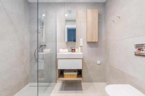 a bathroom with a sink and a shower at Shellter Premium Apartment Beachside by Renters Prestige in Rogowo