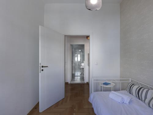 a white room with a bed and a hallway at Beautiful Athenian apartment next to the center in Athens