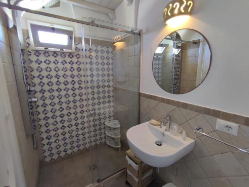 a bathroom with a sink and a shower with a mirror at B&B Punta Cutieri in Gallipoli