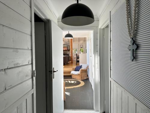 a hallway with a door leading to a living room at White Shell Cottage - Woodfire & Beachfront in Falmouth