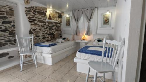 - une chambre avec 2 lits, une table et des chaises dans l'établissement Anoi Rooms, à Tinos