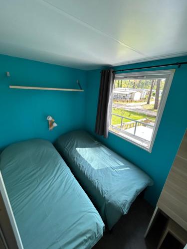 LE ILÔ - camping la dune blanche في كاميير: غرفة نوم صغيرة بها سرير ونافذة