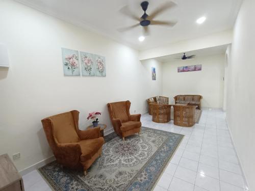 uma sala de espera com 2 cadeiras e uma ventoinha de tecto em Rinting Corner Islamic Homestay, Pasir Gudang em Masai
