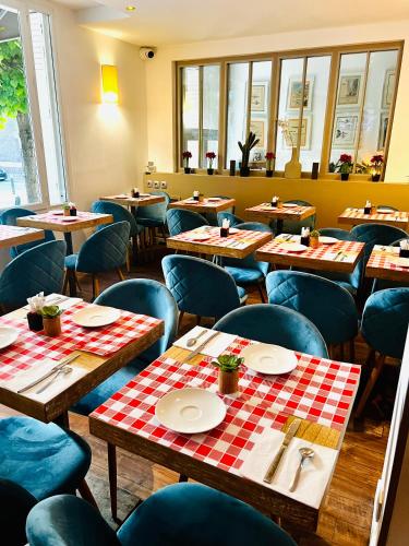 a restaurant with wooden tables and blue chairs at Hotel Douglas in Puteaux