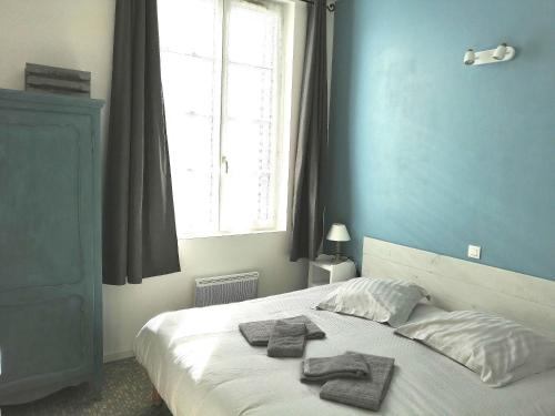 sypialnia z łóżkiem i ręcznikami w obiekcie Appartement montagne w mieście Eaux-Bonnes