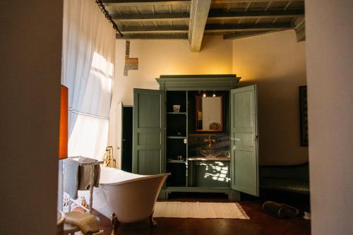 a bathroom with a tub and a green cabinet at Castello del Capitano delle Artiglierie in Castrocaro Terme