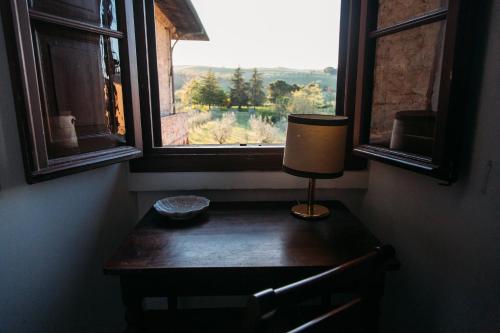 a desk with a lamp in a room with a window at Castello del Capitano delle Artiglierie in Castrocaro Terme