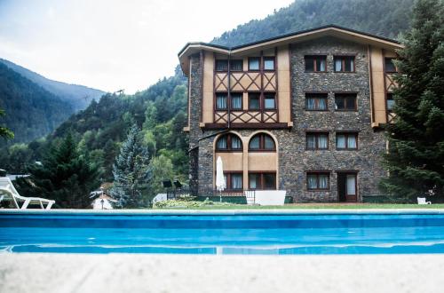 a building with a swimming pool in front of it at Hotel Xalet Verdú in Arinsal