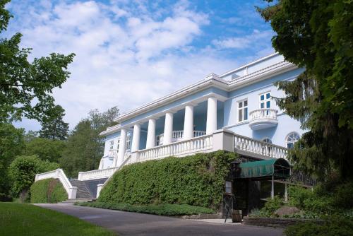 ポルヴォーにあるホテル ハイッコ マナー ＆ スパの白い建物の横にバルコニーがあります。